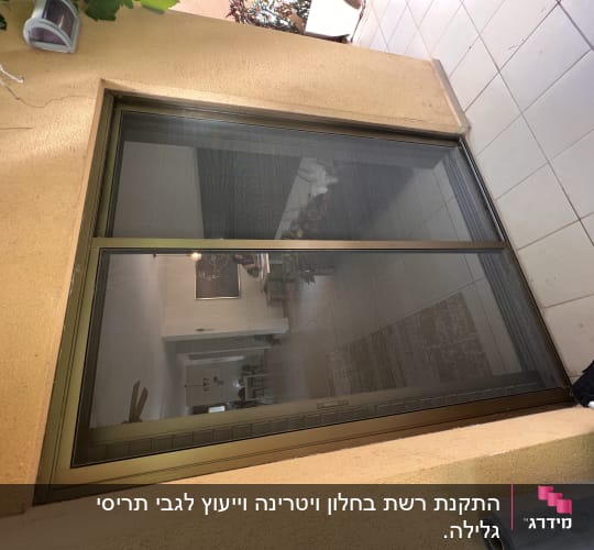 חלון עם תריסים חיצוניים סגורים על קיר חיצוני